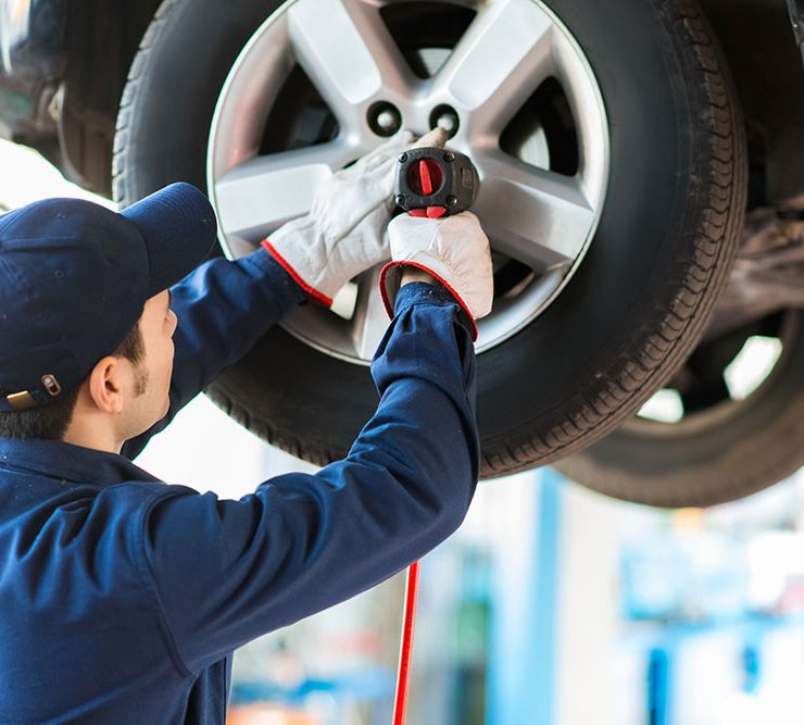 A man servicing a car tire